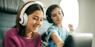 Children with headphones on in a plane.