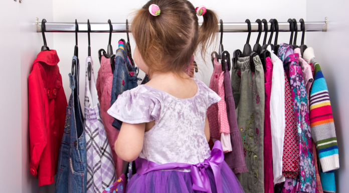 A little girl looking at clothing.