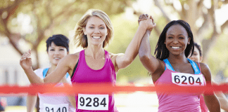 Woman holding hands as they cross the finish line.