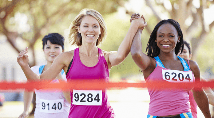 Woman holding hands as they cross the finish line.