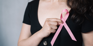 A woman holding a pink breast cancer symbol.