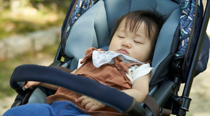 A baby napping in a stroller.