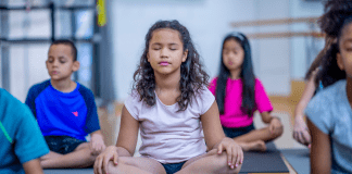 Kids taking a meditation class.