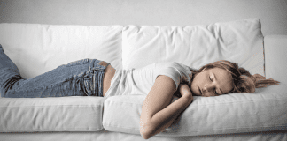 Teen girl sleeping on a couch.
