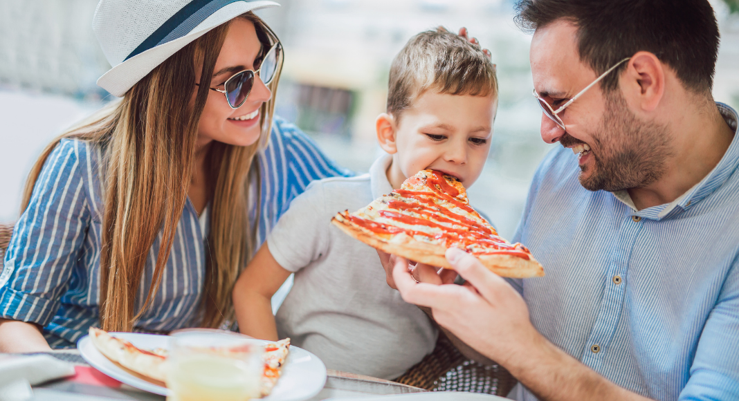 A family eating pizza in a restaurant.