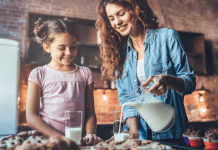 Mom pouring milk for her daughter.