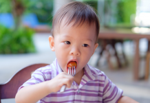 A child feeding himself with a fork.