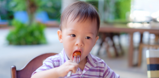 A child feeding himself with a fork.