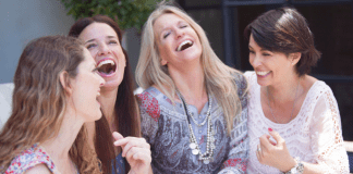 A group of four women laughing.