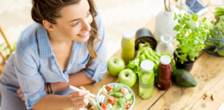 A woman eating a bowl of healthy food.