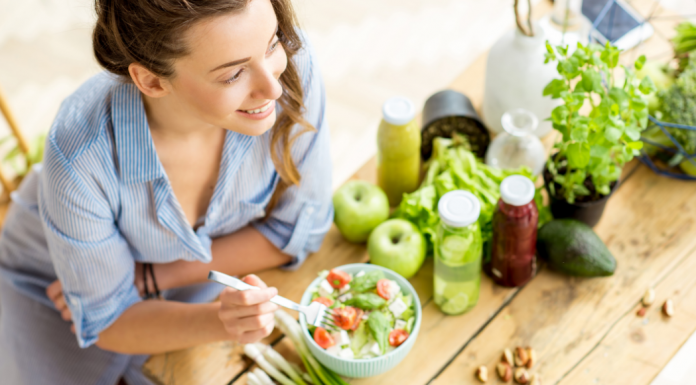 A woman eating a bowl of healthy food.