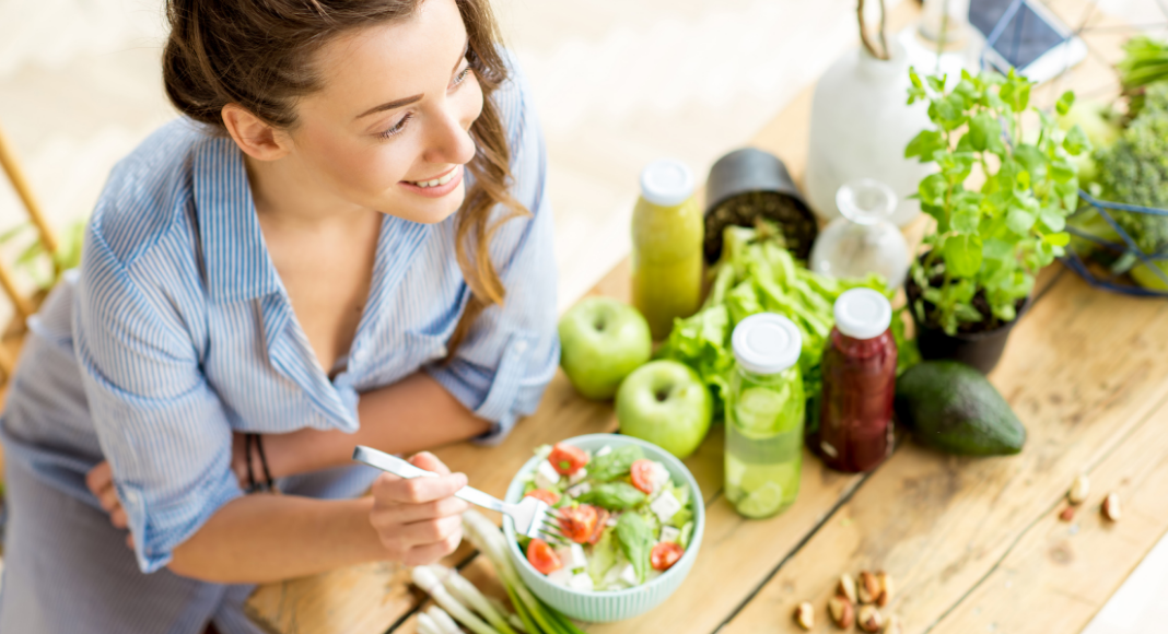 A woman eating a bowl of healthy food. 