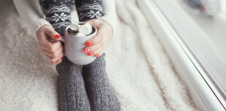 A woman resting holding a hot chocolate.