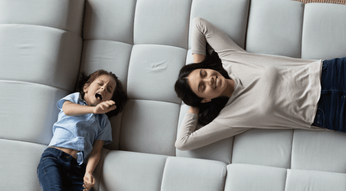 A mom and child laying on pillows.