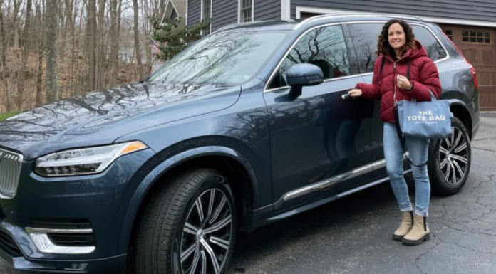 A woman standing next to her Volvo XC90