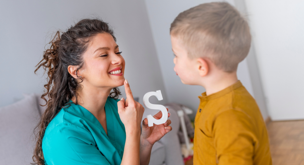 A speech therapist working with a boy.