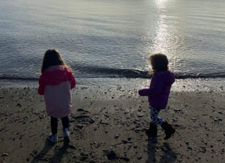 Two girls running on the beach.