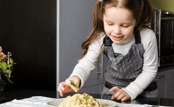 A little girl preparing a meal.