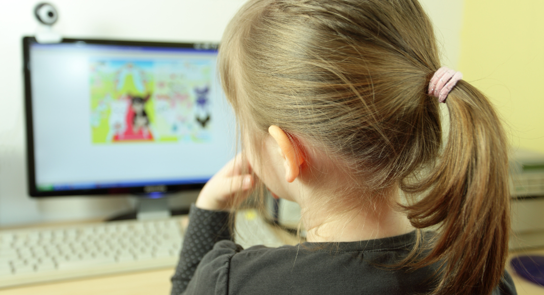 A girl playing a game on the computer.