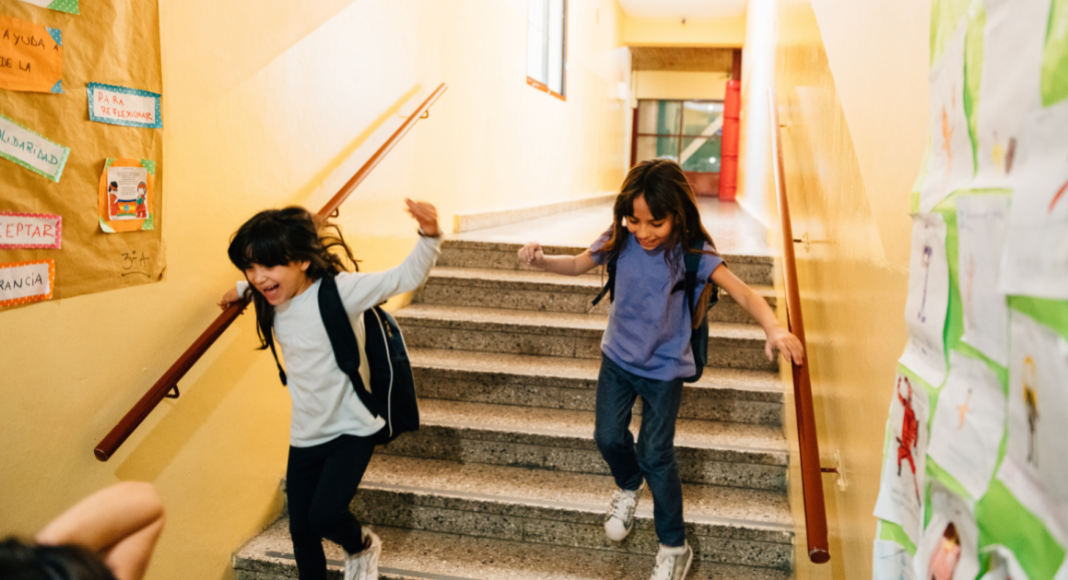 Two students racing down the school stairs.