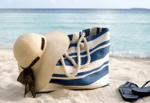 A full beach bag on the sand.