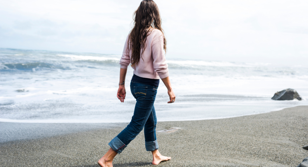 A woman walking on a beach.