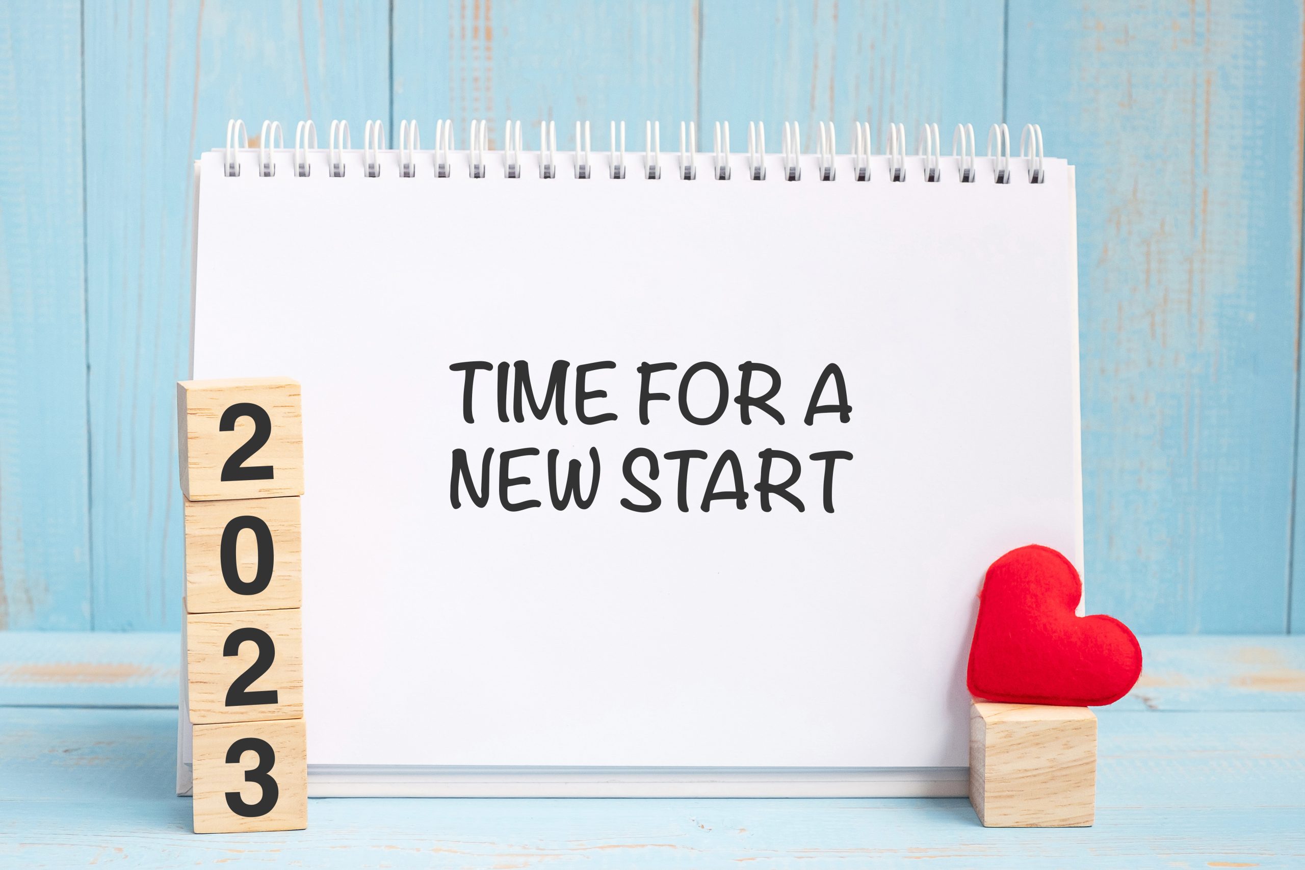 Time for A New Start words and 2023 cubes with red heart shape decoration on blue wooden table background. New Year NewYou, Goal, Resolution, health, Love and Happy Valentine’s day concept