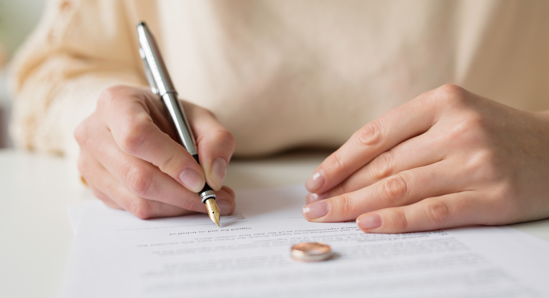 A woman signing divorce papers.